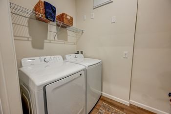 Two white front loading washing machines in a laundry room.